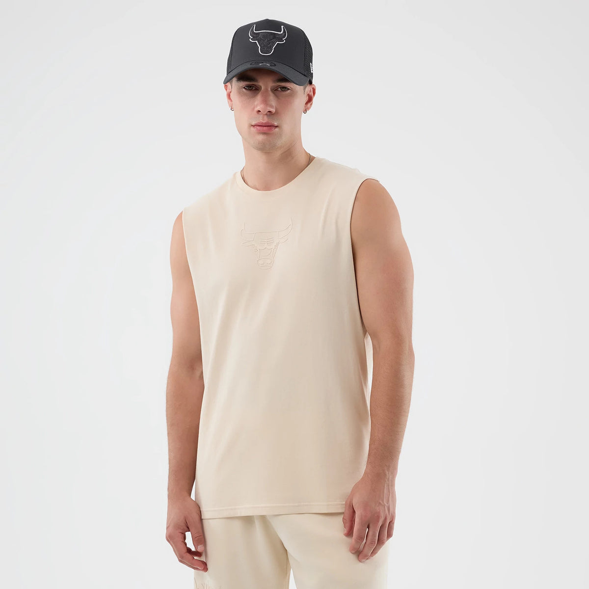 New Era Chicago Bulls NBA Core Plus Light Beige Vest, front view on a model with a matching light beige sleeveless design featuring the Chicago Bulls logo embossed in the centre of the chest, offering a clean and casual look.