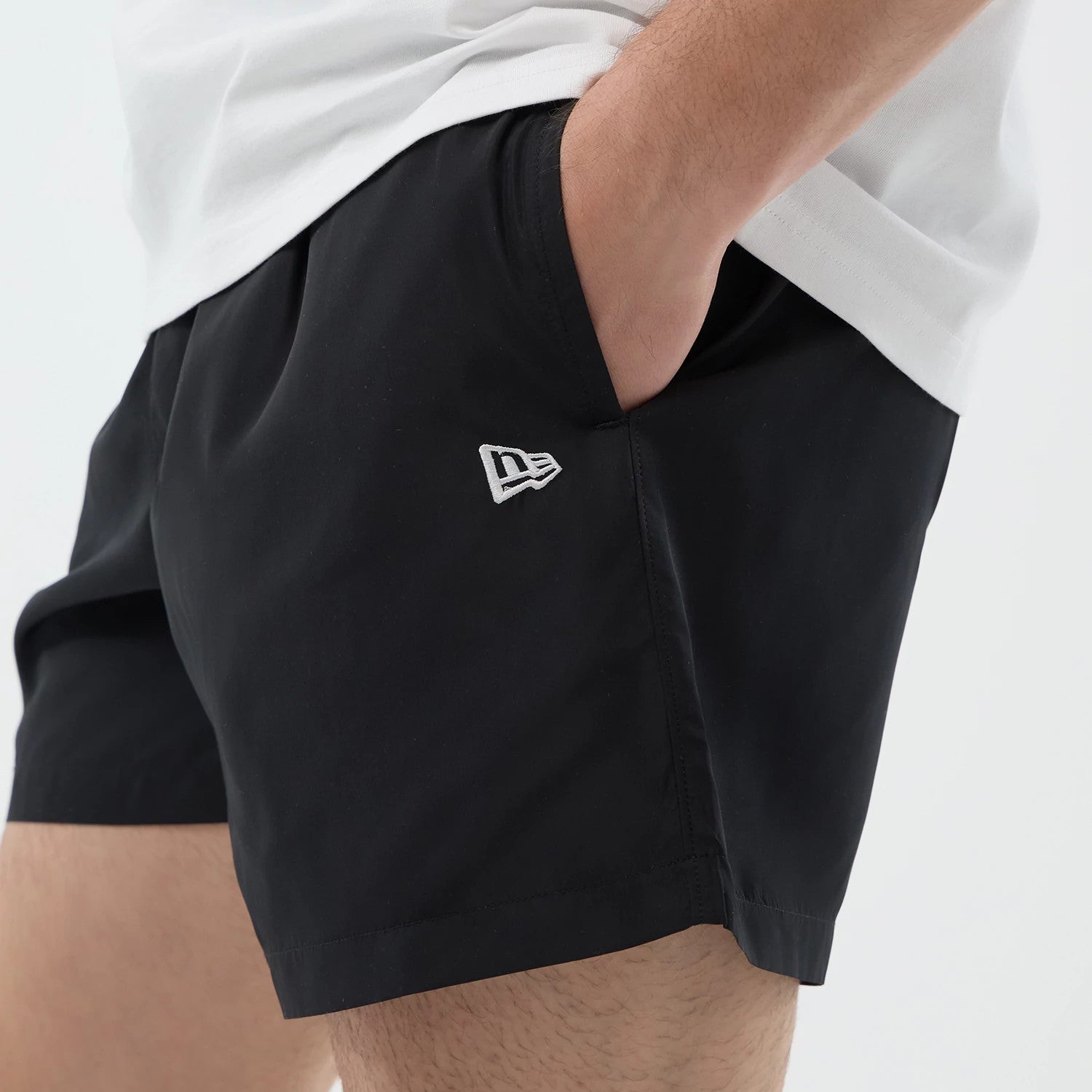 The model is wearing this New Era Swimming Shorts in black. 4