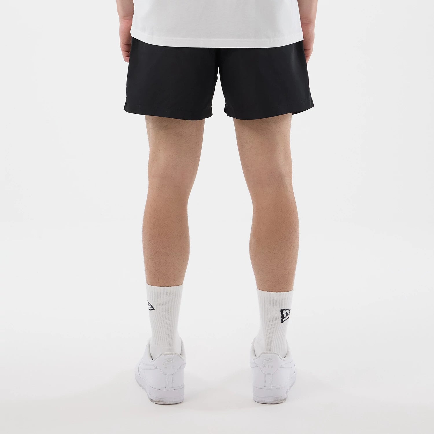 The model is wearing this New Era Swimming Shorts in black. 2
