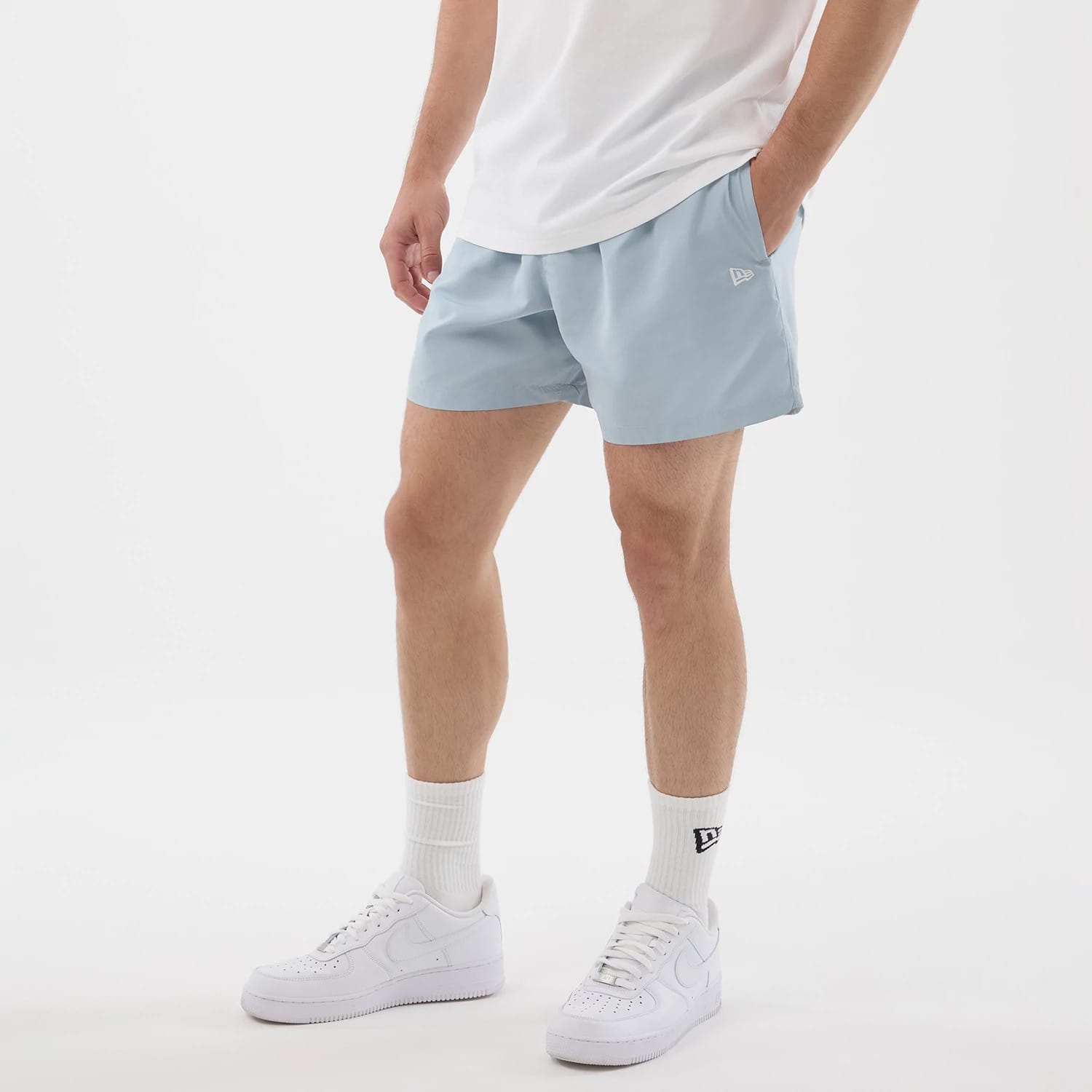 The model is wearing this New Era Swimming Shorts in pastel blue. 3