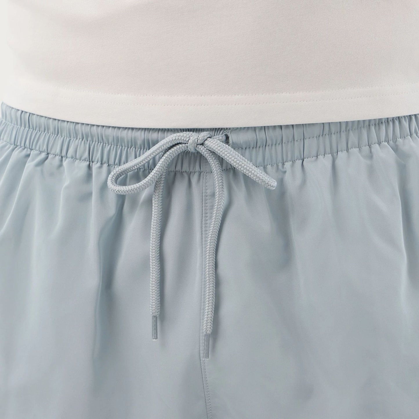 The model is wearing this New Era Swimming Shorts in pastel blue. 7