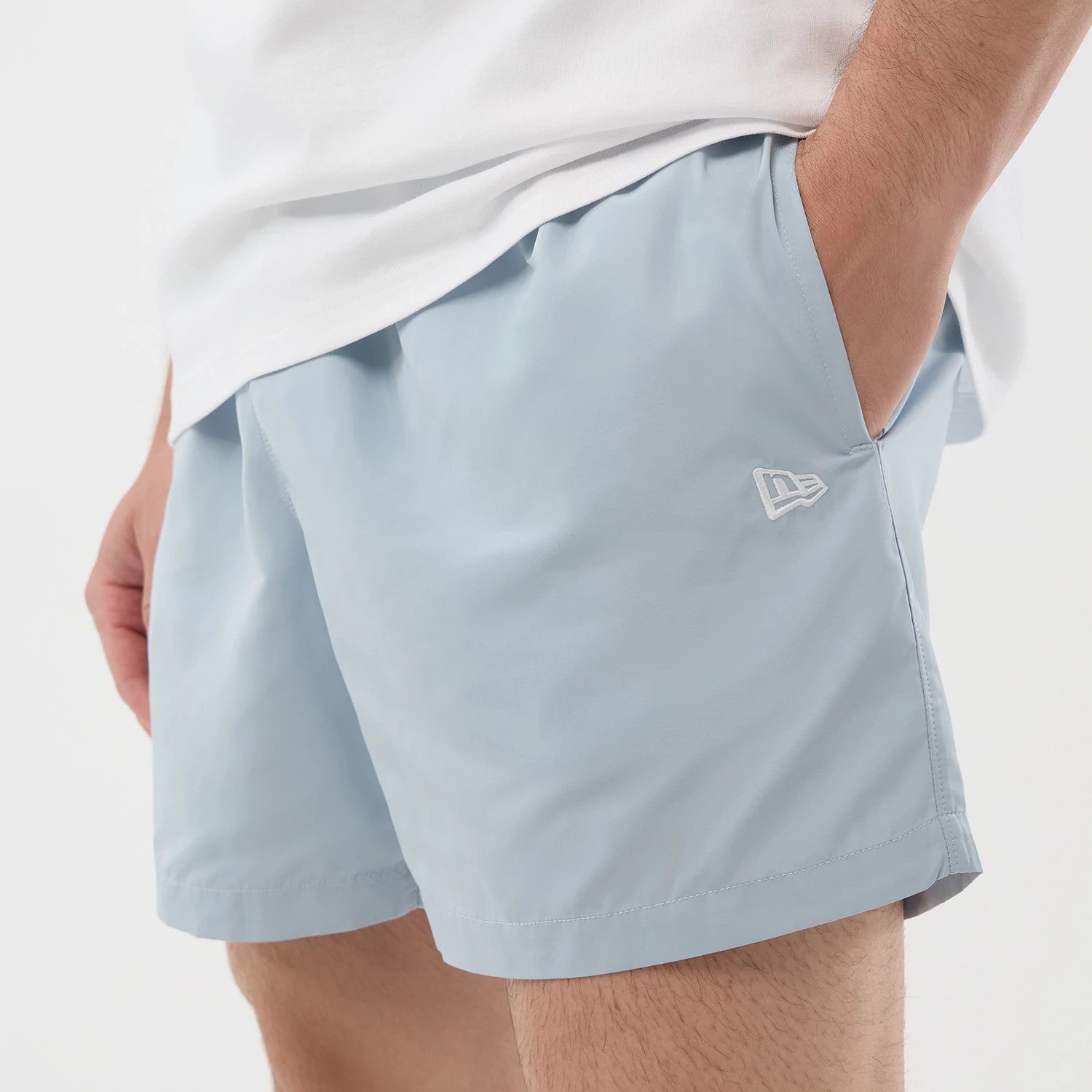 The model is wearing this New Era Swimming Shorts in pastel blue. 4