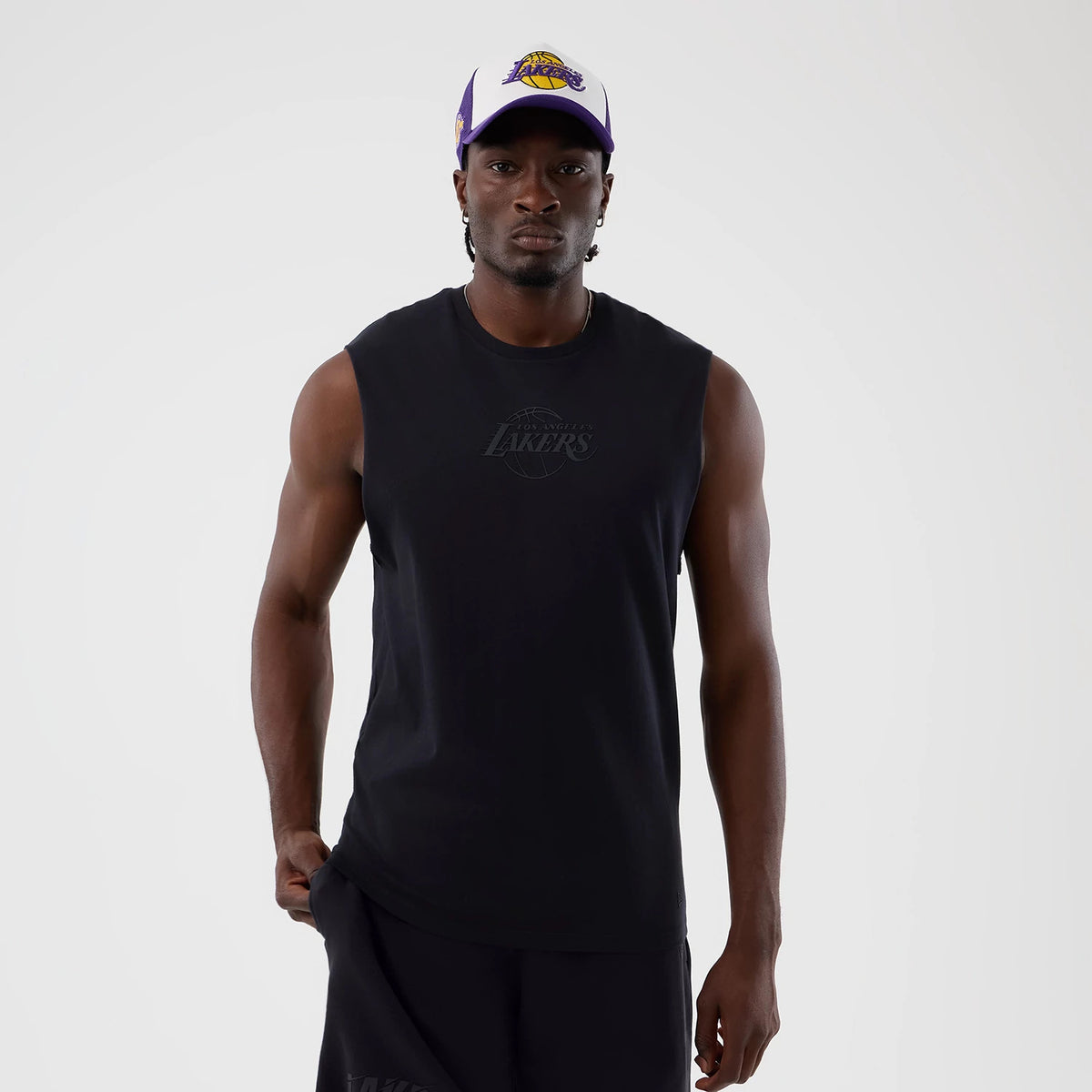 New Era LA Lakers NBA Core Plus Navy Vest, front view on a model wearing a matching cap, with a embroidered Lakers logo on the chest, sleeveless design, and relaxed fit for casual styling.