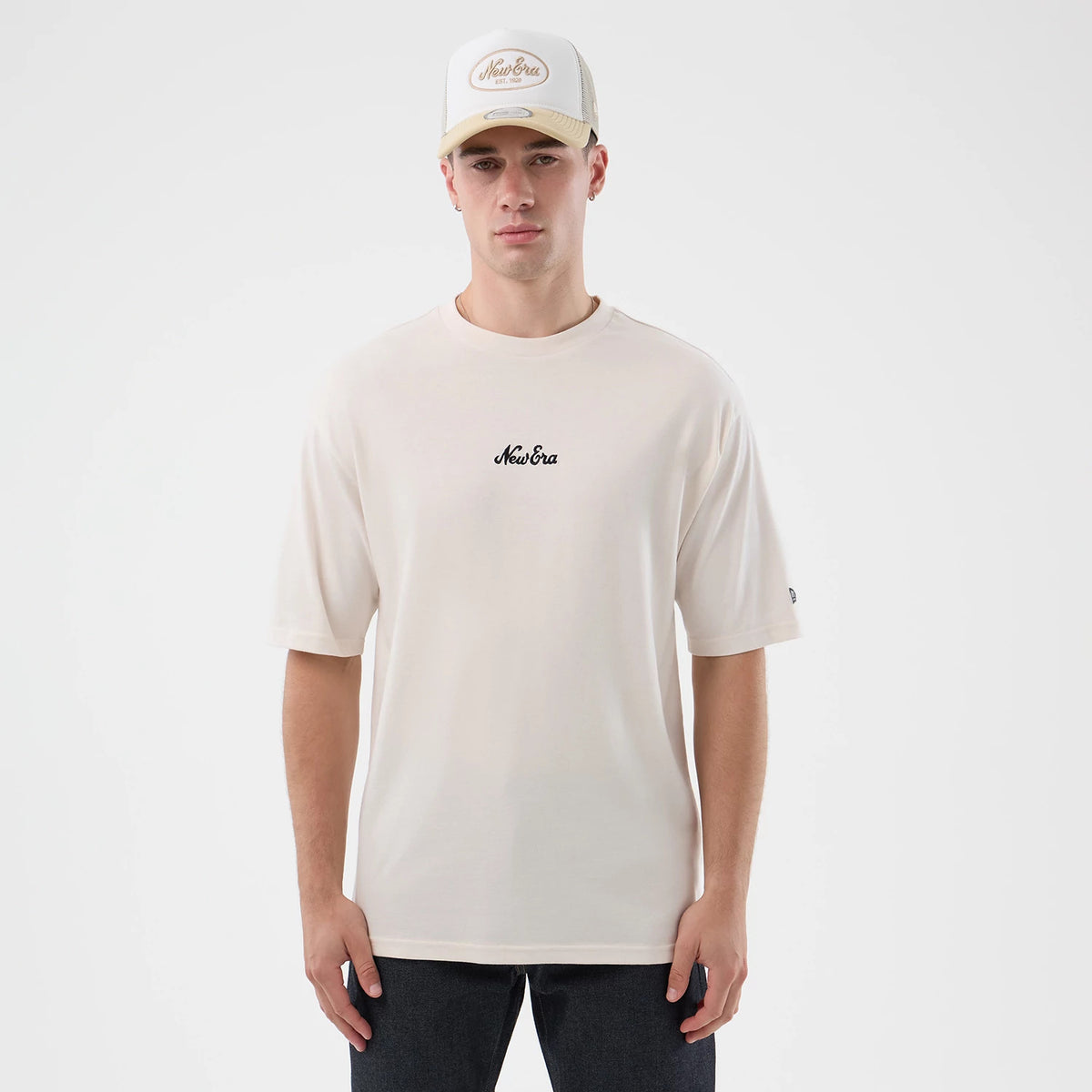 New Era Floral Graphic Open White Oversized T-Shirt, front view on-model showing a relaxed fit with a black embroidered New Era logo centred on the chest and another black embroidered logo on the sleeve, styled with a matching white cap.