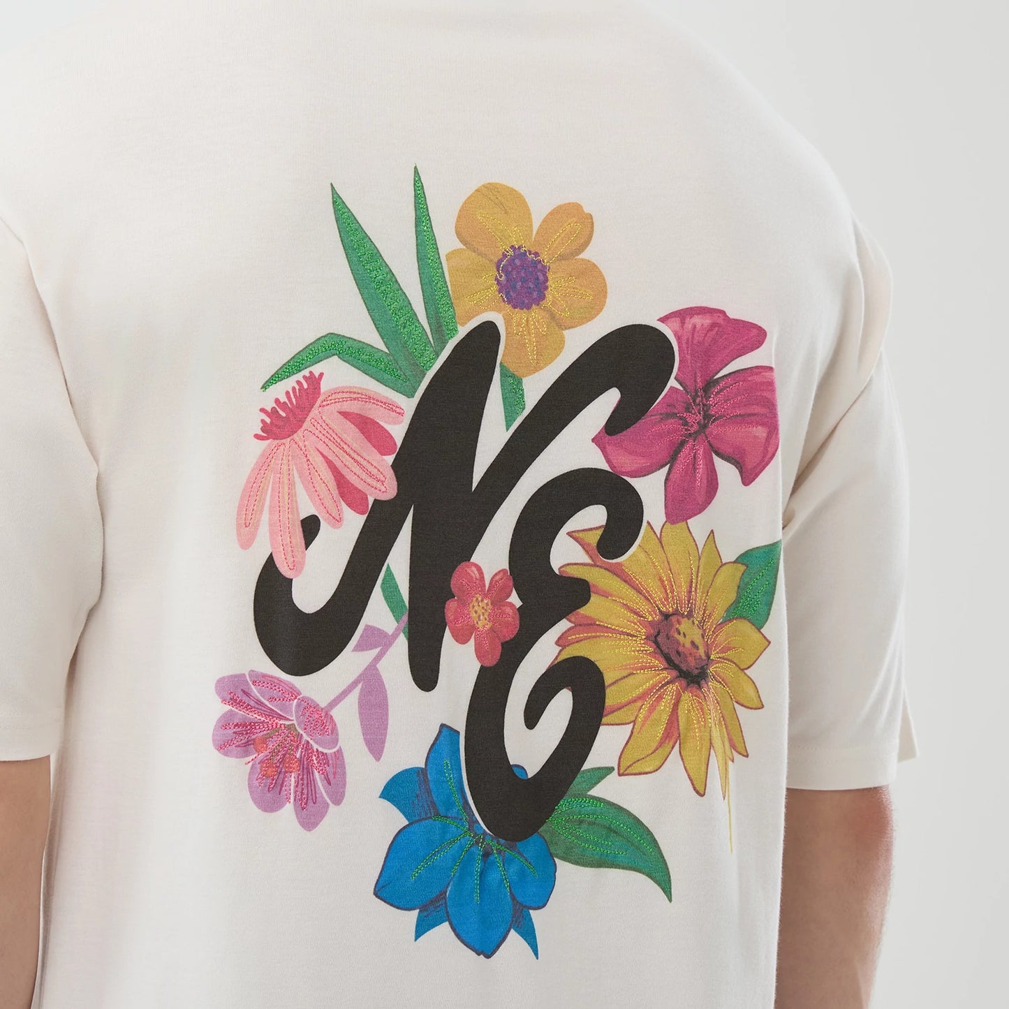The model is wearing this New Era Floral Graphic Oversized T-Shirt in open white. 7