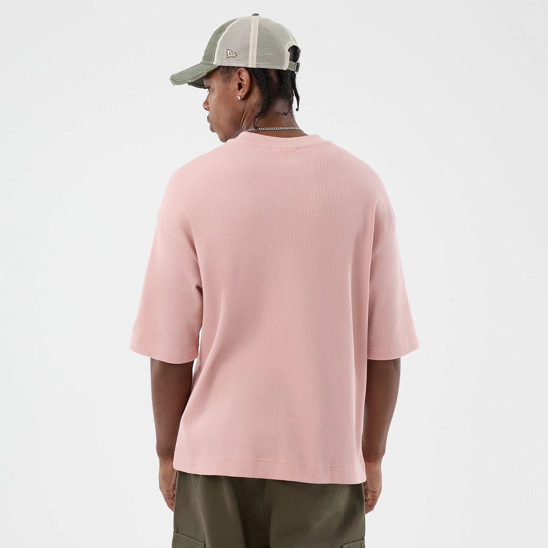 The model is wearing this New Era Waffle T-Shirt in pastel pink. 2