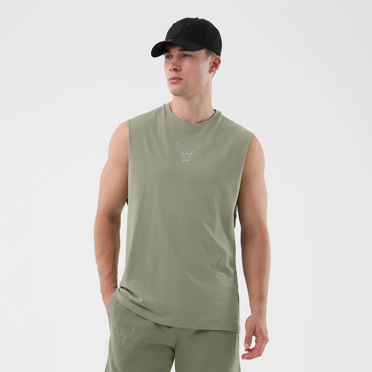 New Era Chicago Bulls NBA League Essential Pastel Green Vest, front view on a model wearing a black cap, featuring the Bulls logo embroidered in white on the chest and matching joggers with a logo near the pocket.