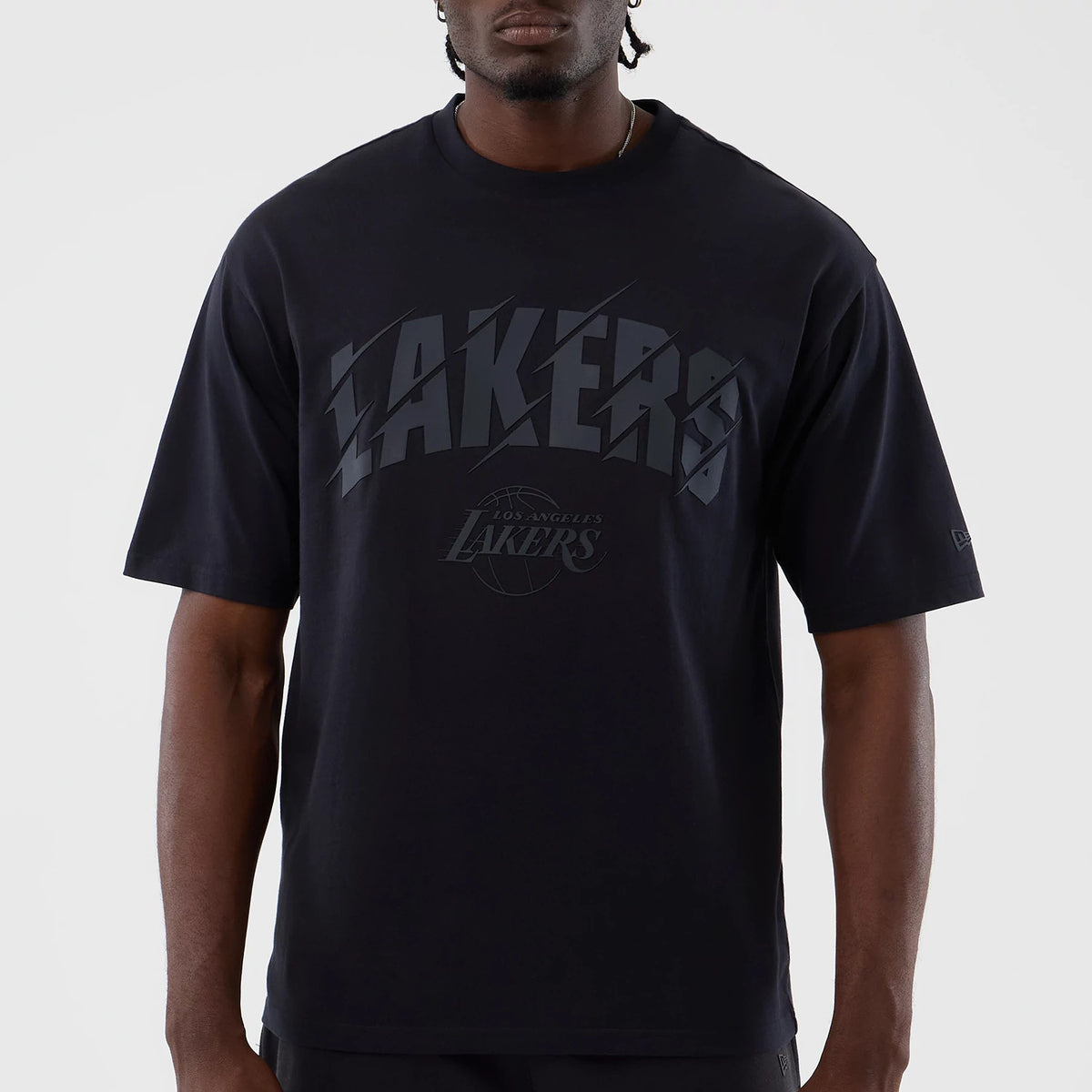 New Era LA Lakers NBA Core Plus Navy Oversized T-Shirt, front view showing raised Lakers lettering across the chest with a smaller Los Angeles Lakers logo beneath, worn by a model with short sleeves and a round neckline.