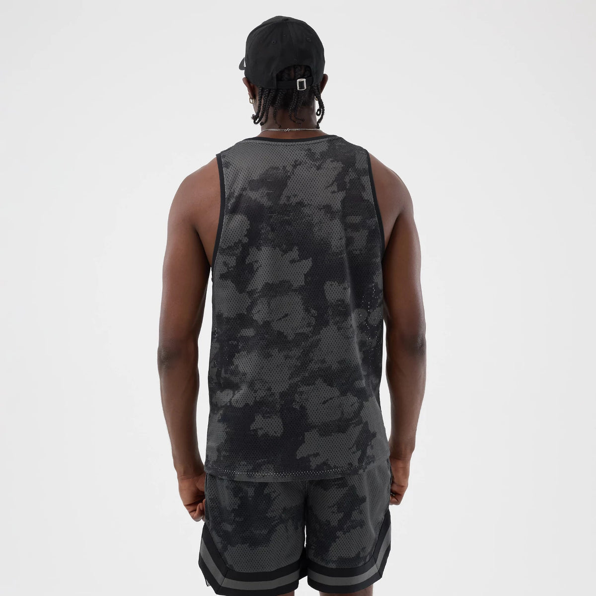 New Era All Over Print Black Camo Mesh Tank Top, back view on a model showcasing the black and grey camo pattern across the mesh fabric, sleeveless design with black trim, and coordinated with matching camo shorts for a complete look.