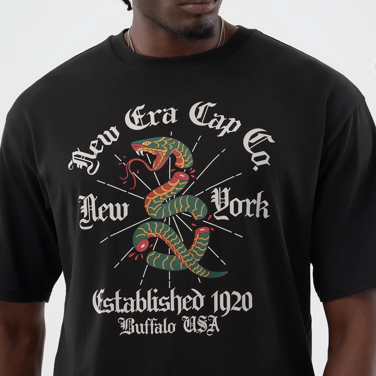 The model is wearing this New Era Serpent Graphic Oversized T-Shirt in black. 4