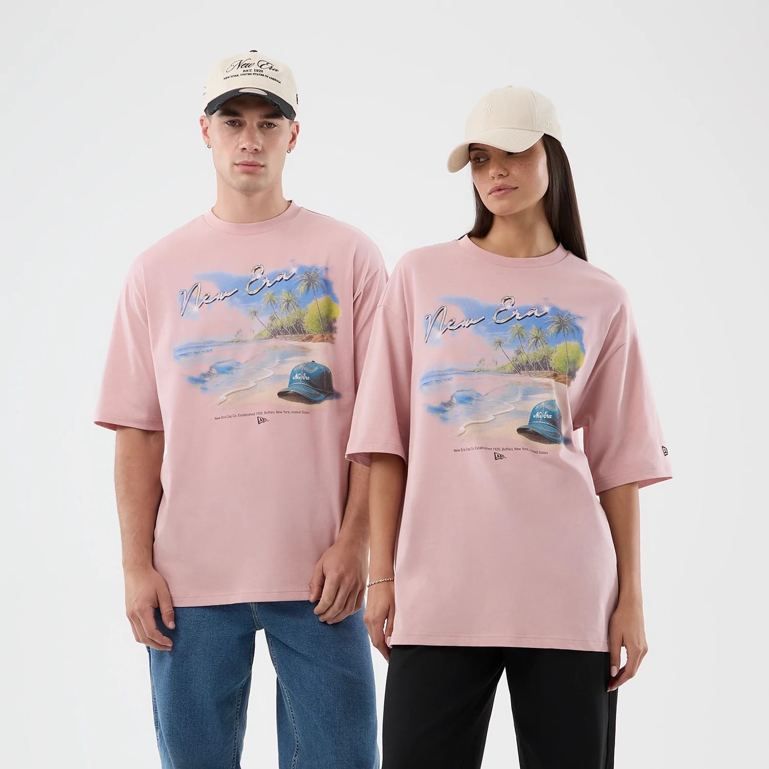 The model is wearing this New Era Beach Graphic Oversized T-Shirt in pastel pink. 1