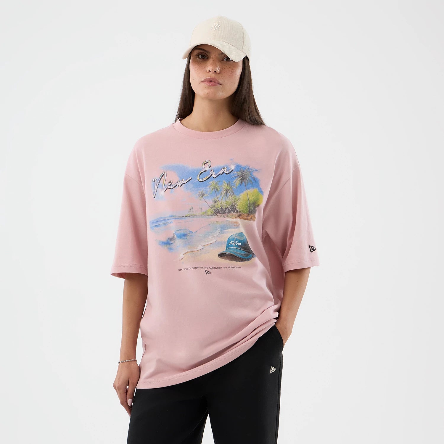 The model is wearing this New Era Beach Graphic Oversized T-Shirt in pastel pink. 4