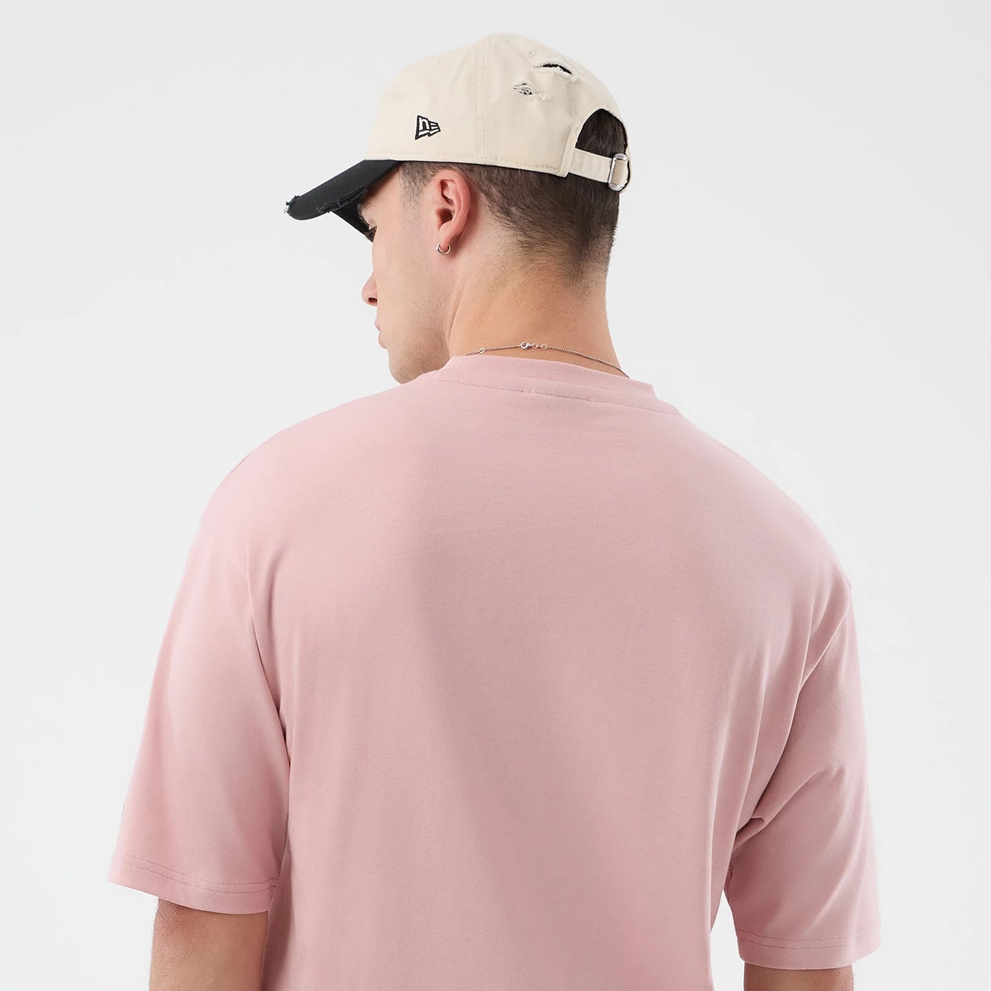 The model is wearing this New Era Beach Graphic Oversized T-Shirt in pastel pink. 8