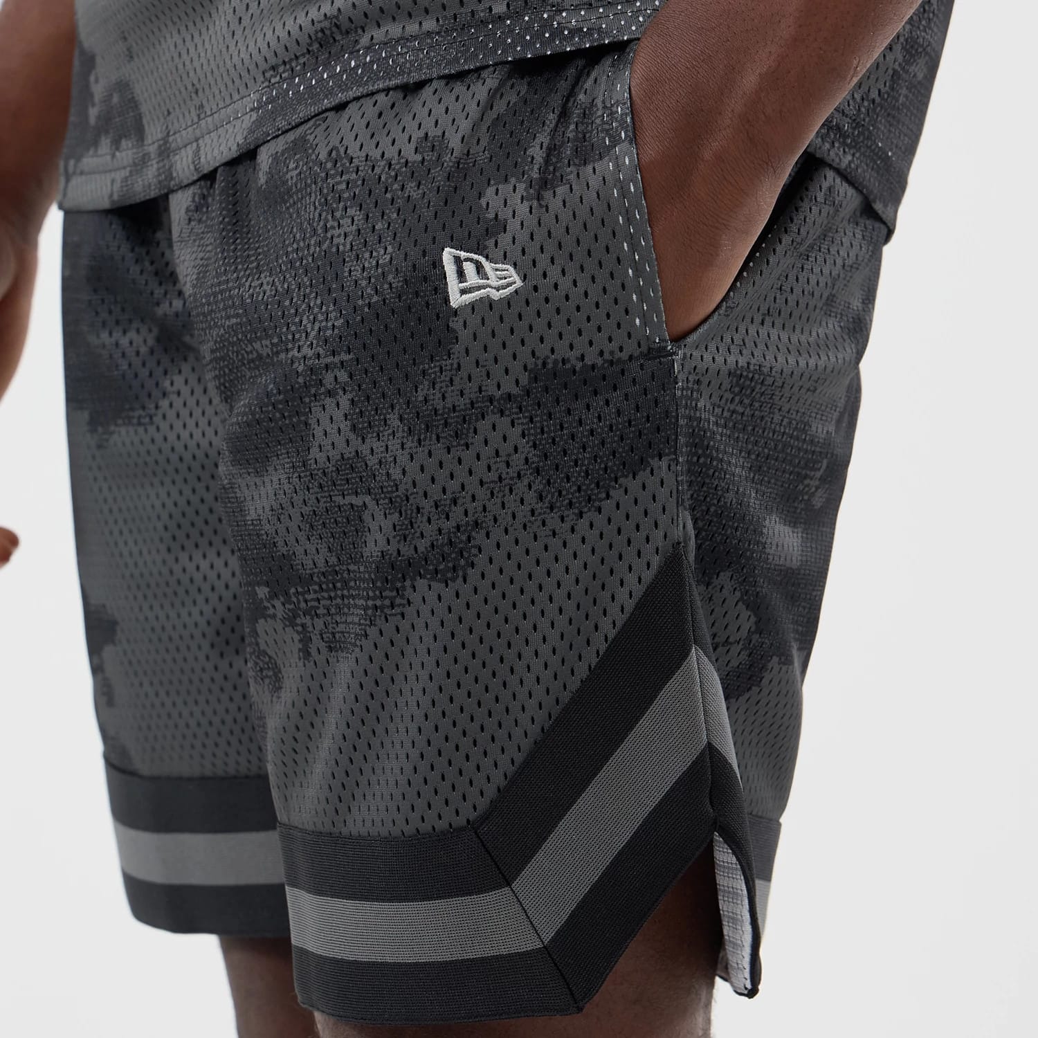 The model is wearing this New Era All Over Print Mesh Shorts in black camo. 4