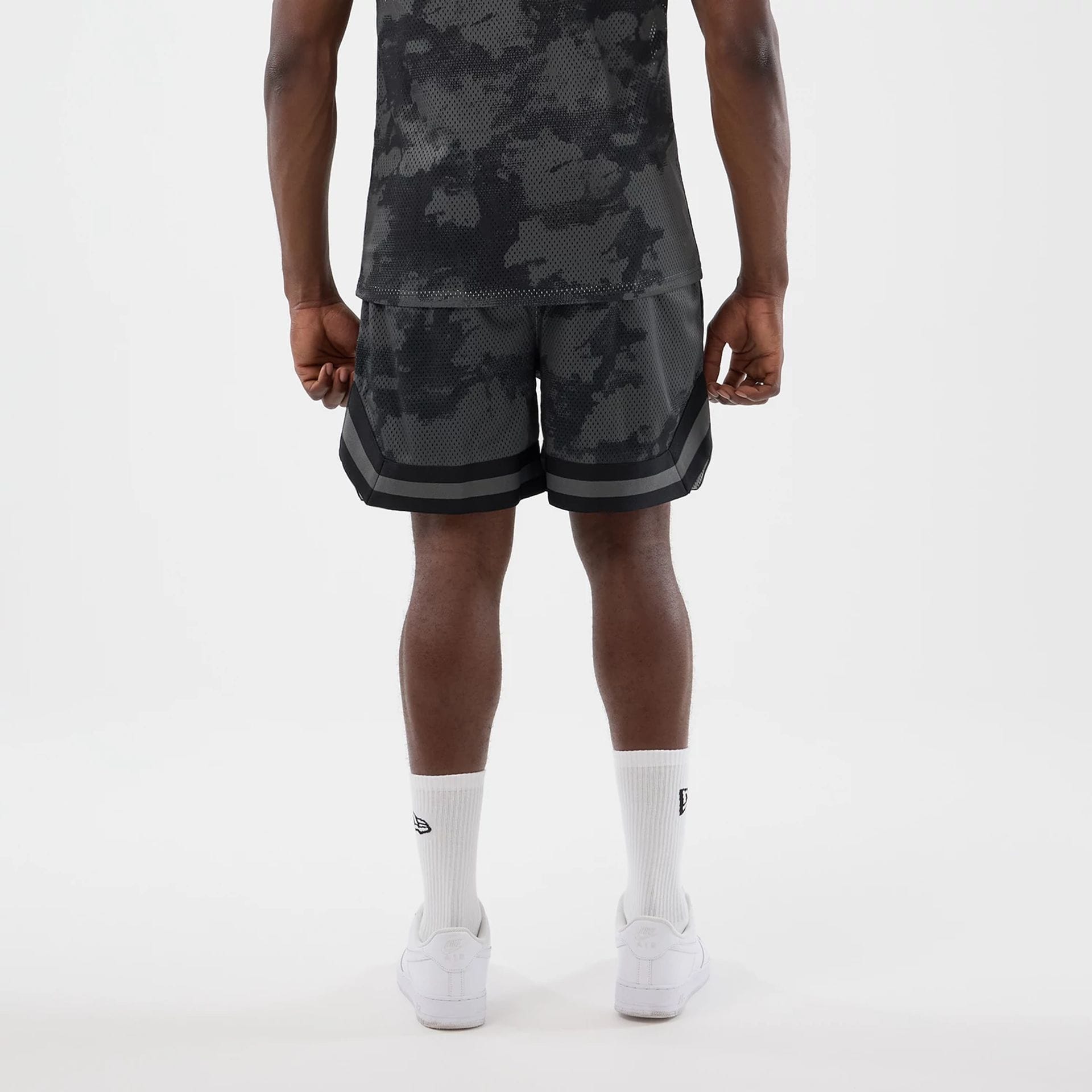 The model is wearing this New Era All Over Print Mesh Shorts in black camo. 2