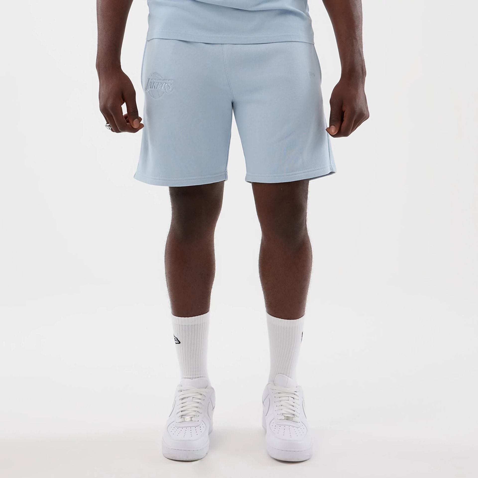 The model is wearing this NBA League Essential LA Lakers Shorts in pastel blue. 1