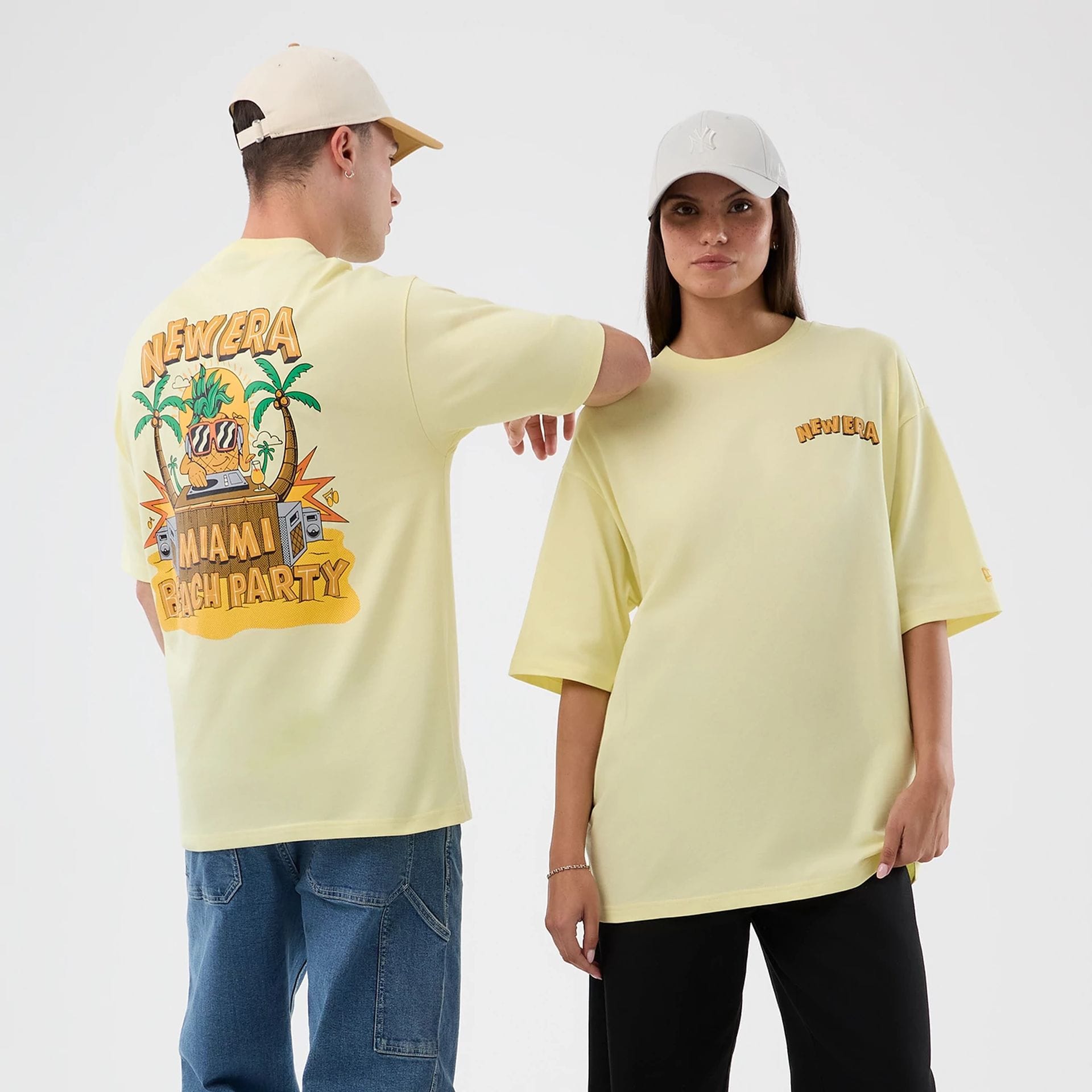 The model is wearing this New Era Fun Beach Party Graphic Oversized T-Shirt in pastel yellow. 1