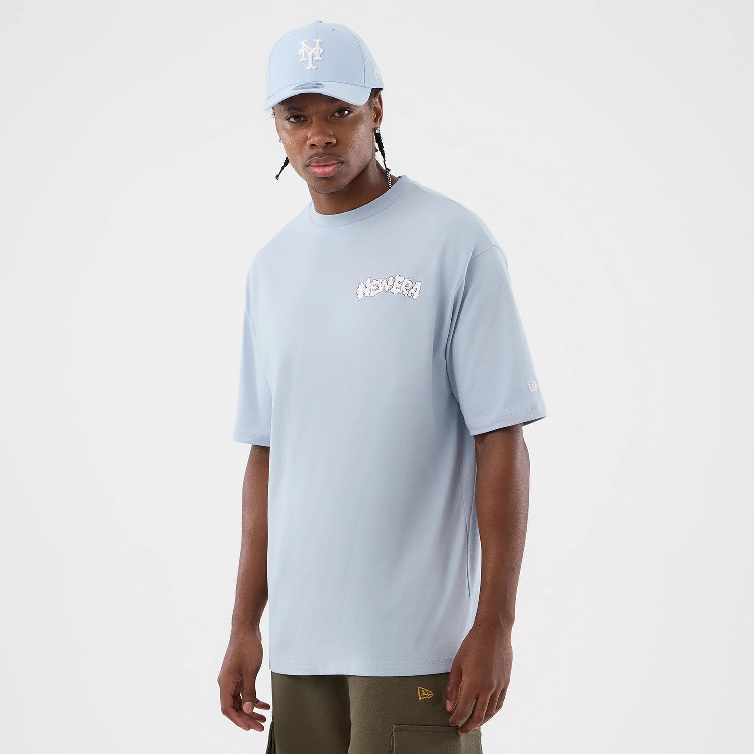 The model is wearing this New Era Fun Block Party Graphic Oversized T-Shirt in pastel blue. 3