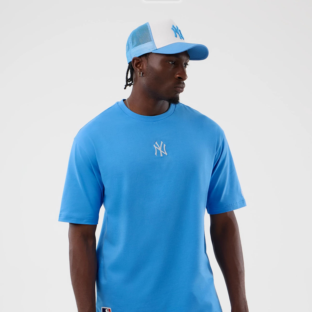 New Era New York Yankees MLB League Essential Pastel Blue Oversized T-Shirt, front view on-model featuring a white embroidered Yankees logo at the centre of the chest, styled with a pastel blue.