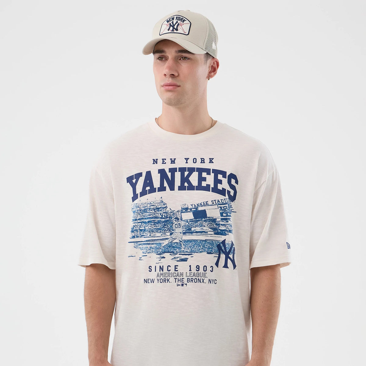 New Era New York Yankees MLB Slub Open White Oversized T-Shirt, front view on-model featuring large blue Yankees branding across the chest with a graphic of Yankee Stadium, printed New Era logo on the left sleeve and paired with a matching cap.