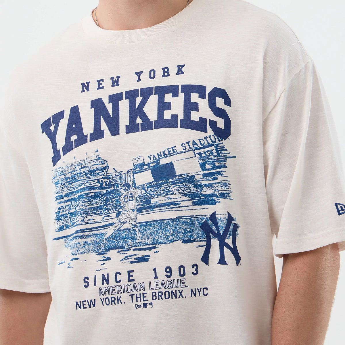 New Era New York Yankees MLB Slub Open White Oversized T-Shirt, front view on-model showing a large blue Yankees stadium graphic across the chest, New York Yankees lettering above, and a printed New York logo near the bottom.