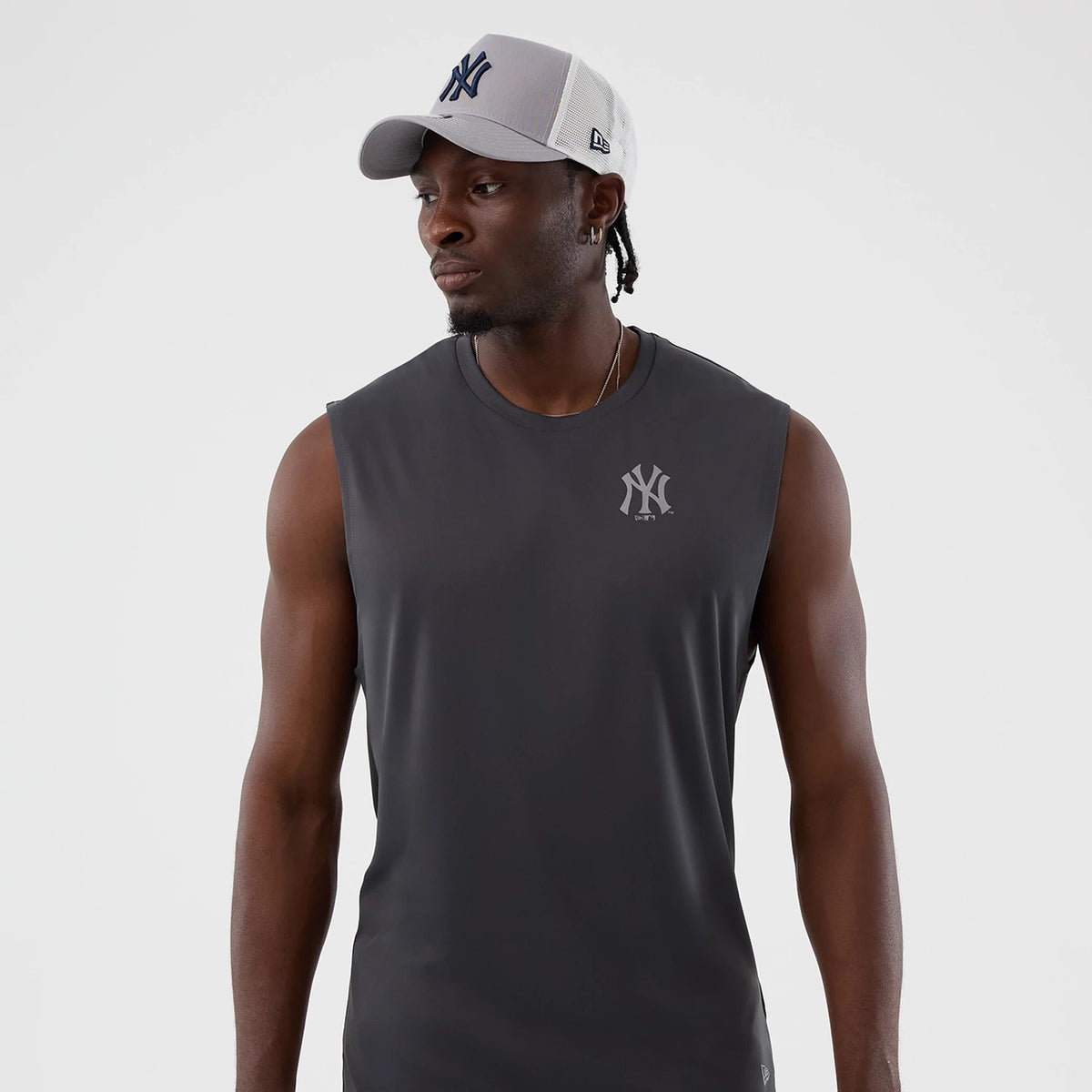 New Era New York Yankees MLB Core Plus Dark Grey Vest, front view on a model wearing a New Era 9FORTY cap, featuring the small grey Yankees logo on the left chest, sleeveless design, and dark grey fabric.