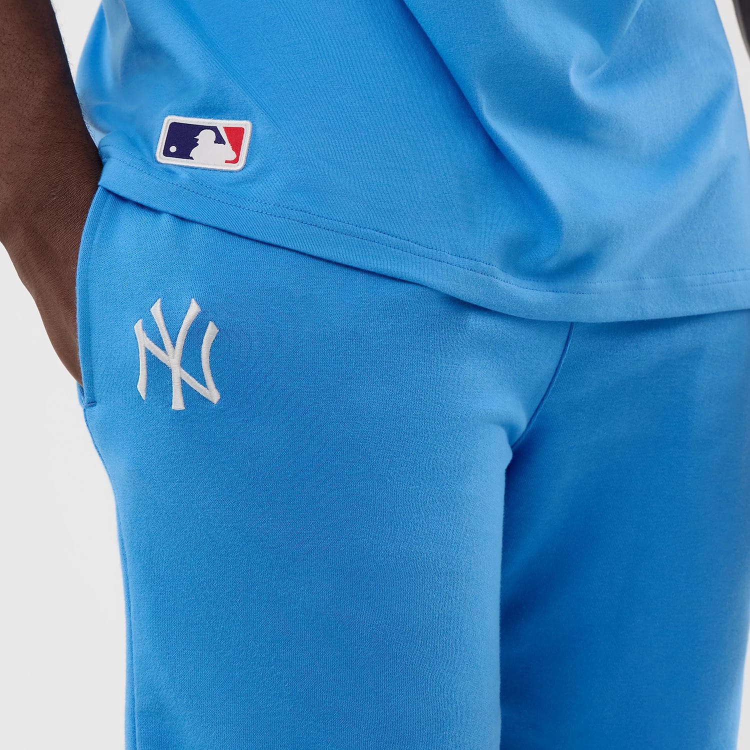 The model is wearing this MLB League Essential New York Yankees Shorts in pastel blue. 4