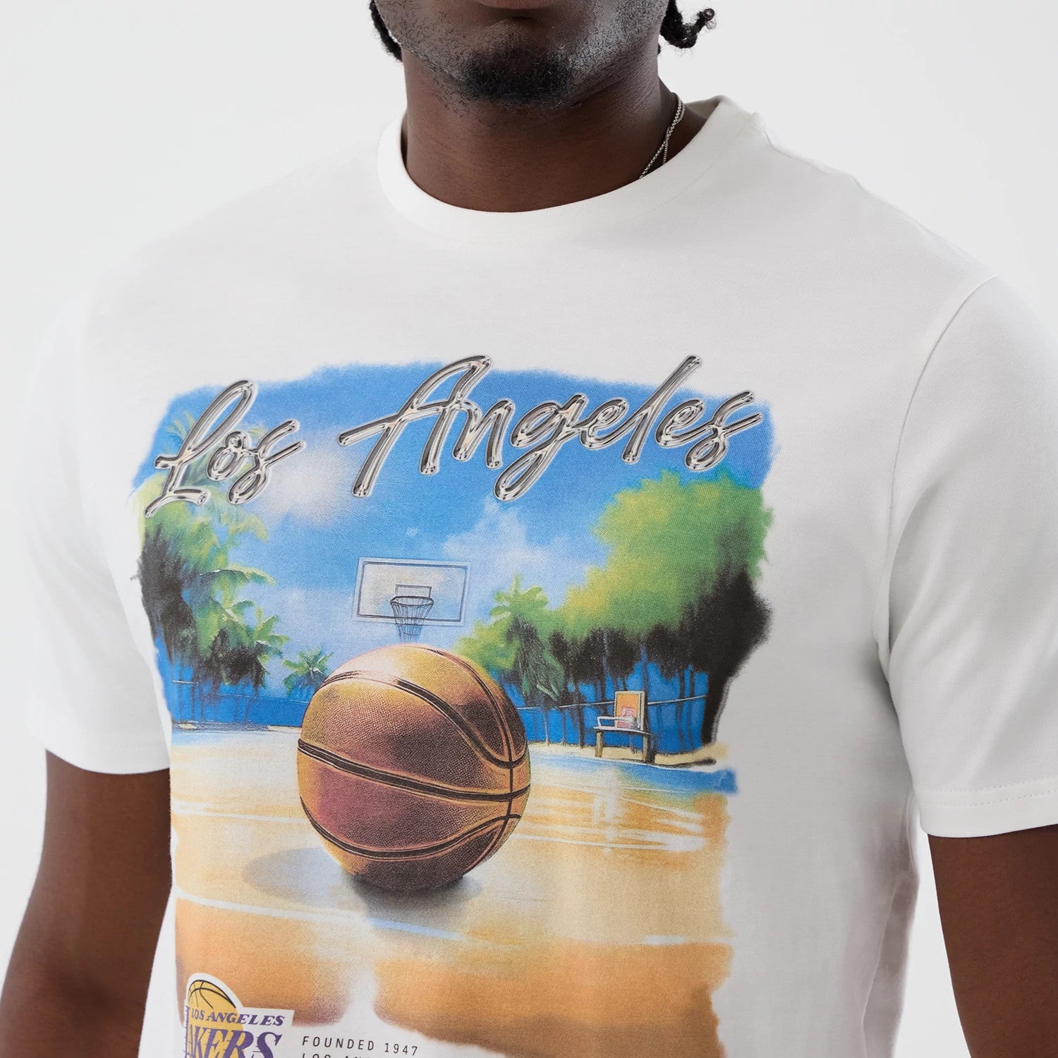 The model is wearing this NBA Beach Graphic LA Lakers T-Shirt in white. 4
