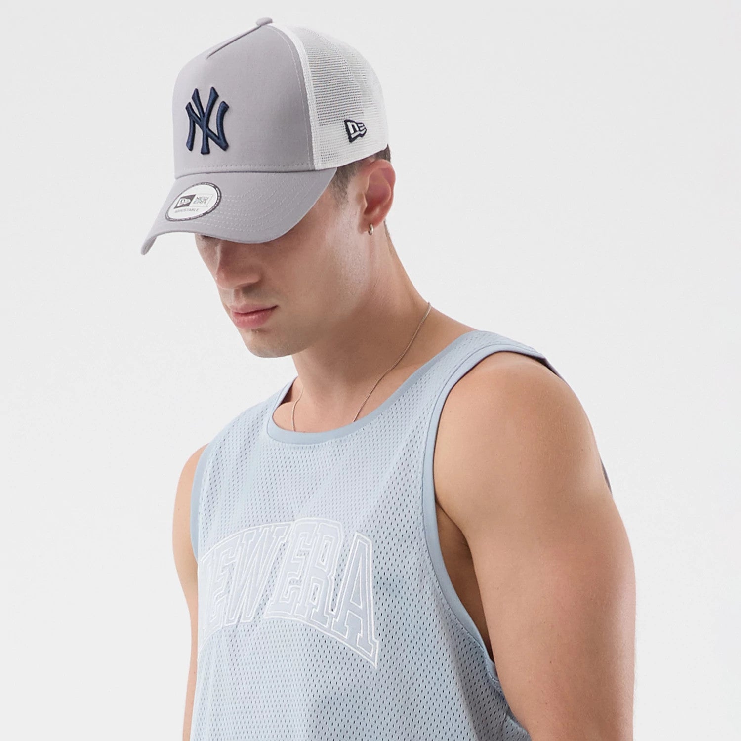 The model is wearing this New Era Mesh Oversized Tank Top in pastel blue. 4