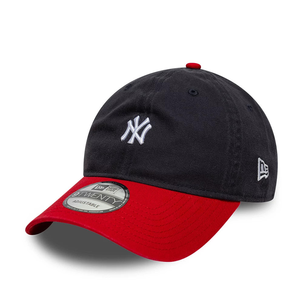 New York Yankees MLB Washed Contrast Navy New Era 9TWENTY Adjustable Cap, three-quarter view showing the white embroidered NY logo on the front panel, contrasting red curved visor with a 9TWENTY size sticker, and New Era flag logo on the left side.