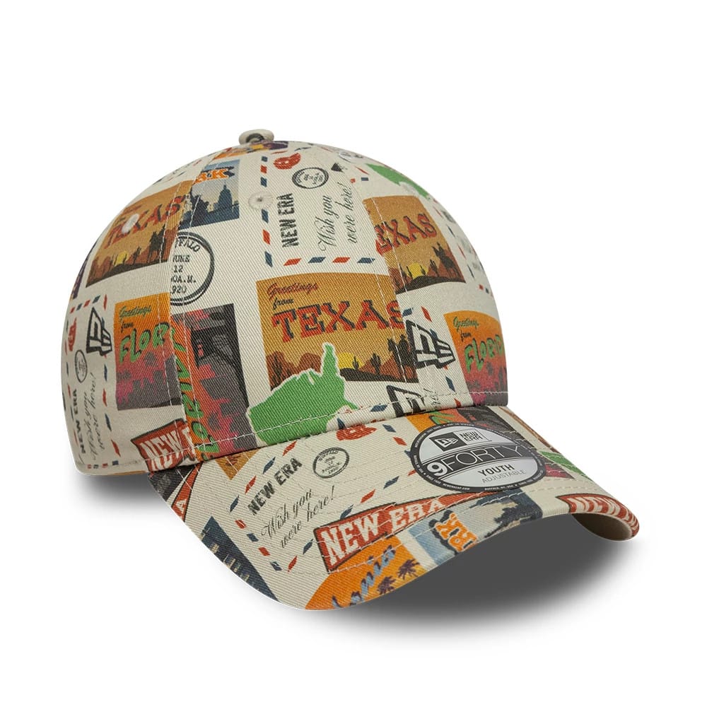 Youth New Era Location Light Beige 9FORTY Adjustable Cap, front view showing a colourful all-over graphic of travel-themed postcards across the structured crown, the New Era flag logo embroidered on the left panel.