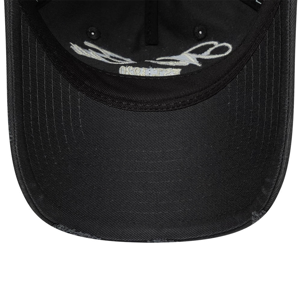 New Era Wash Distress Charcoal 9TWENTY A-Frame Adjustable Cap, inside view showing the black undervisor with a stitched pattern, white taping with signatures, and a texture detail along the edge of the cap's curved visor.