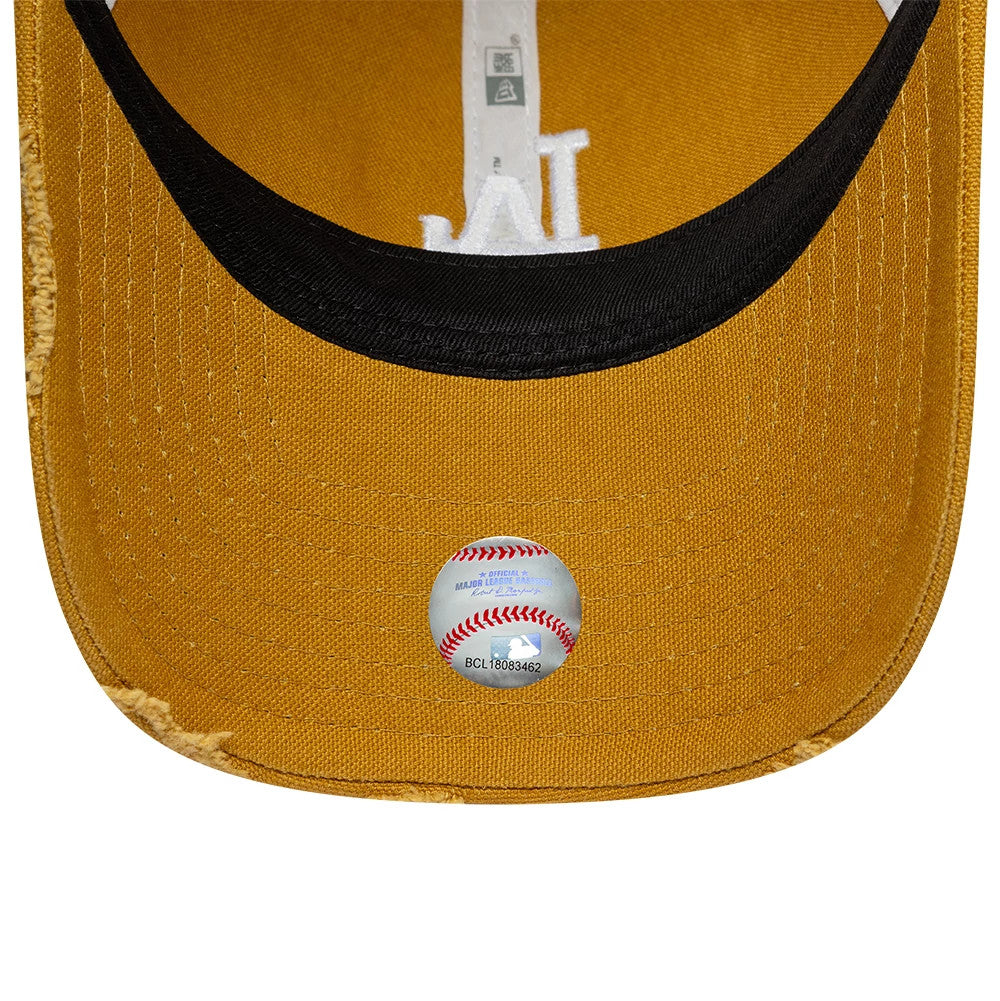 LA Dodgers MLB Cotton Canvas Beige New Era 9TWENTY Trucker Adjustable Cap, inside view showing a black undervisor with a round baseball-themed sticker, white taping along the interior, and an embroidered LA logo peeking beneath the sweatband.
