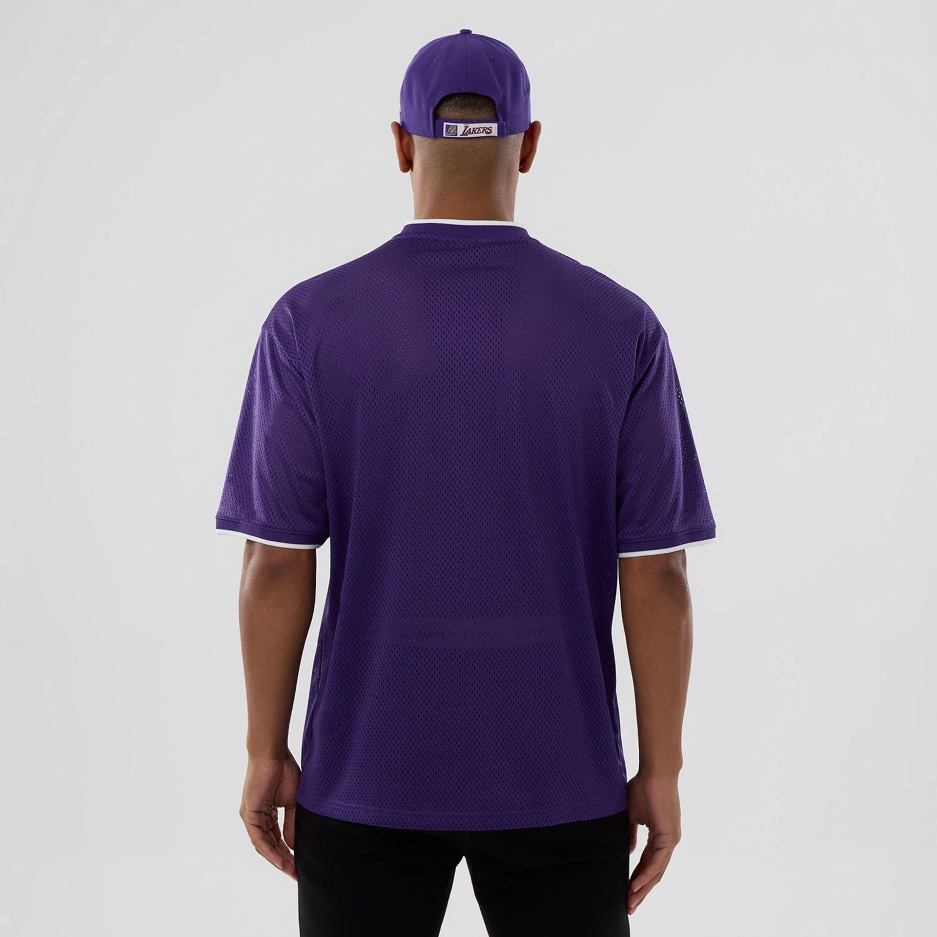 The model is wearing this NBA Mesh LA Lakers Oversized T-Shirt in purple. 2