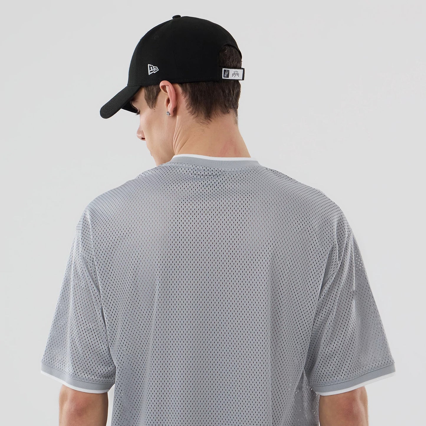 The model is wearing this NBA Mesh San Antonio Spurs Oversized T-Shirt in grey. 7