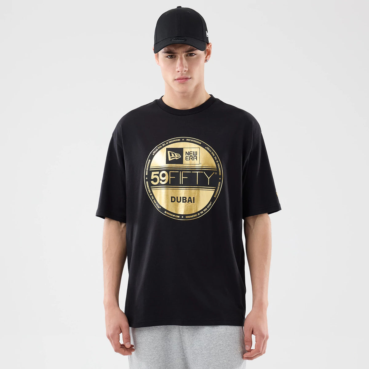The model is wearing this New Era Sticker Dubai Oversized T-Shirt in black. 1