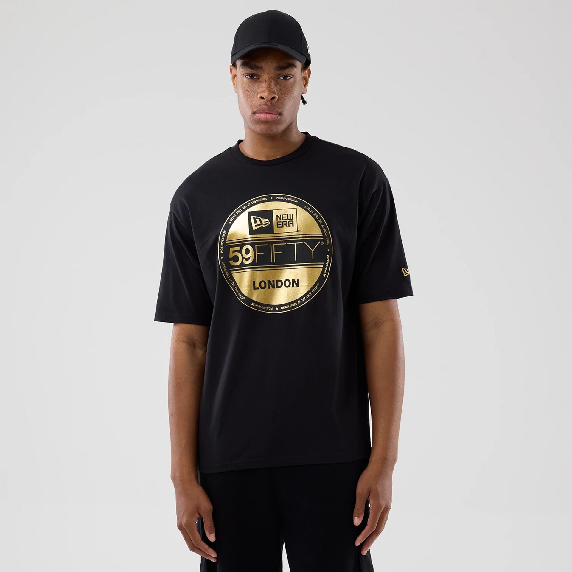 The model is wearing this New Era Sticker London Oversized T-Shirt in black. 1