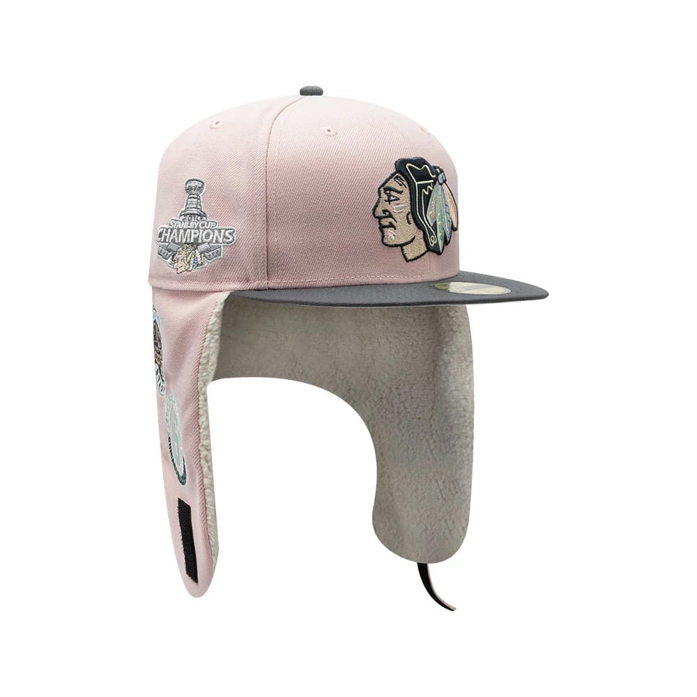 Chicago Blackhawks NHL Patch Pastel Pink New Era 59FIFTY Fitted Cap, three-quarter view showing the raised embroidered Blackhawks logo on the front panel, grey visor with 59FIFTY size sticker, and soft ear flaps with cream lining.