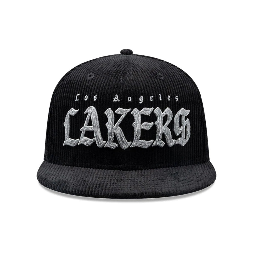 LA Lakers NBA Old English Black New Era 9FIFTY Snapback Cap, front view showing raised white embroidered Los Angeles lettering above LAKERS across the structured corduroy black crown, with a matching curved visor and top button.