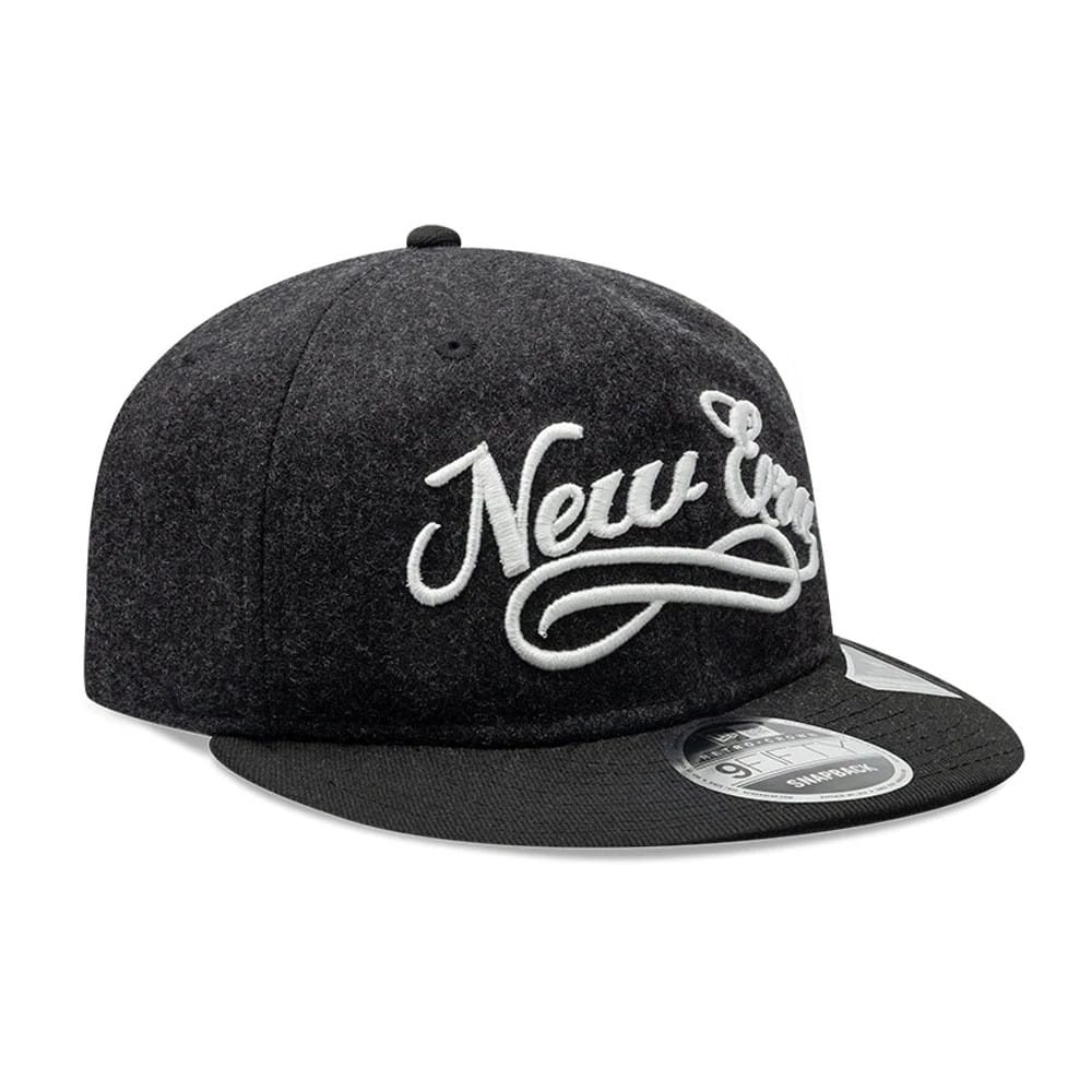 New Era Melton Wool Black Retro Crown 9FIFTY Cap, three-quarter view showing the large white raised embroidered script logo on the front panel, black flat visor with a 9FIFTY size sticker, and a matching black top button.