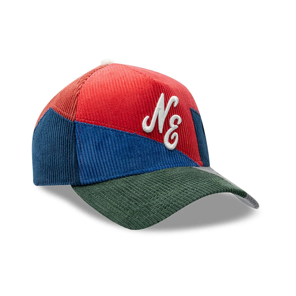 New Era Patchwork Red 9FORTY A-Frame Cap, three-quarter view showing the white raised embroidered NE logo on the red and blue patchwork front panels, with a green visor and textured fabric design.