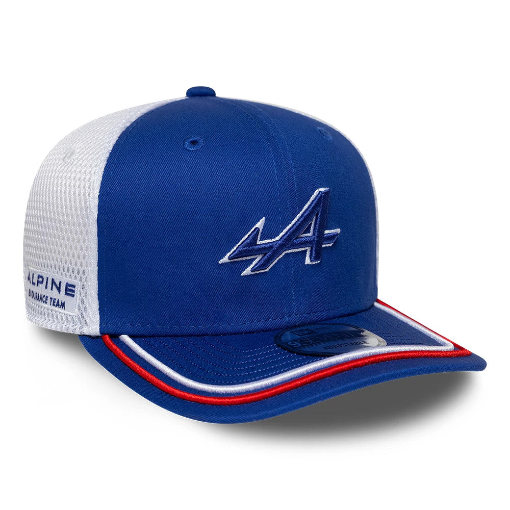 Alpine Racing WEC 2025 Blue New Era 9SEVENTY Stretch Snap Cap, three-quarter view showing the blue embroidered A logo on the front panel, a blue curved visor with red and white trim, and a 9SEVENTY size sticker.