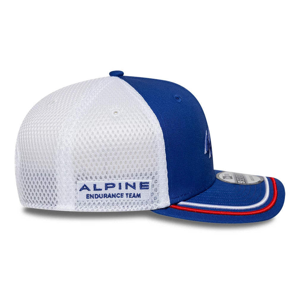 Alpine Racing WEC 2025 Blue New Era 9SEVENTY Stretch Snap Cap, side view showing the Alpine Endurance Team logo in blue embroidery on the white mesh panels, along with a structured blue front panel, and a curved blue visor with red and white trim.