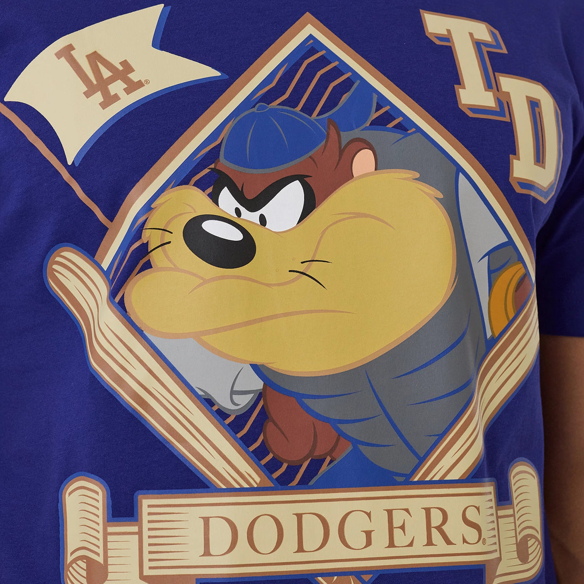 New Era LA Dodgers MLB X Looney Tunes Dark Blue T-Shirt, front view showing an eye-catching graphic of Taz inside a diamond shape, accompanied by the Dodgers wordmark below, and an LA logo flag on the left shoulder area.