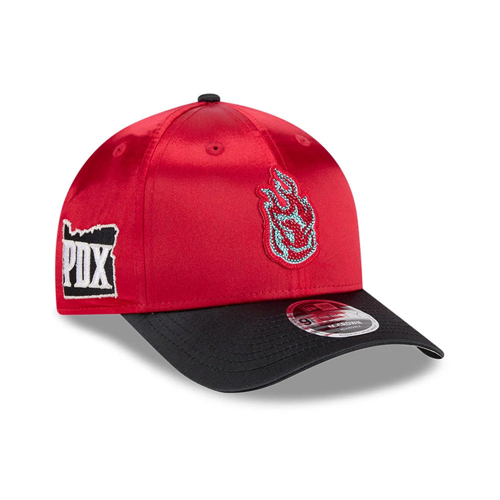Portland Fire WNBA Draft 2026 Red New Era 9FORTY M-Crown Adjustable Cap, front view showing a flame emblem embroidered in blue and white on the red structured crown, a PDX patch on the left side, and a curved black visor with a 9FORTY size sticker.
