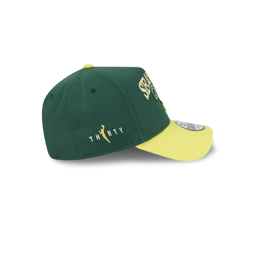 Seattle Storm WNBA Tip Off 2026 Dark Green New Era 9FORTY A-Frame Adjustable Cap, side view showing a yellow THIRTY logo embroidered on the green structured crown, with a contrasting yellow visor and a 9FORTY size sticker on the visor.