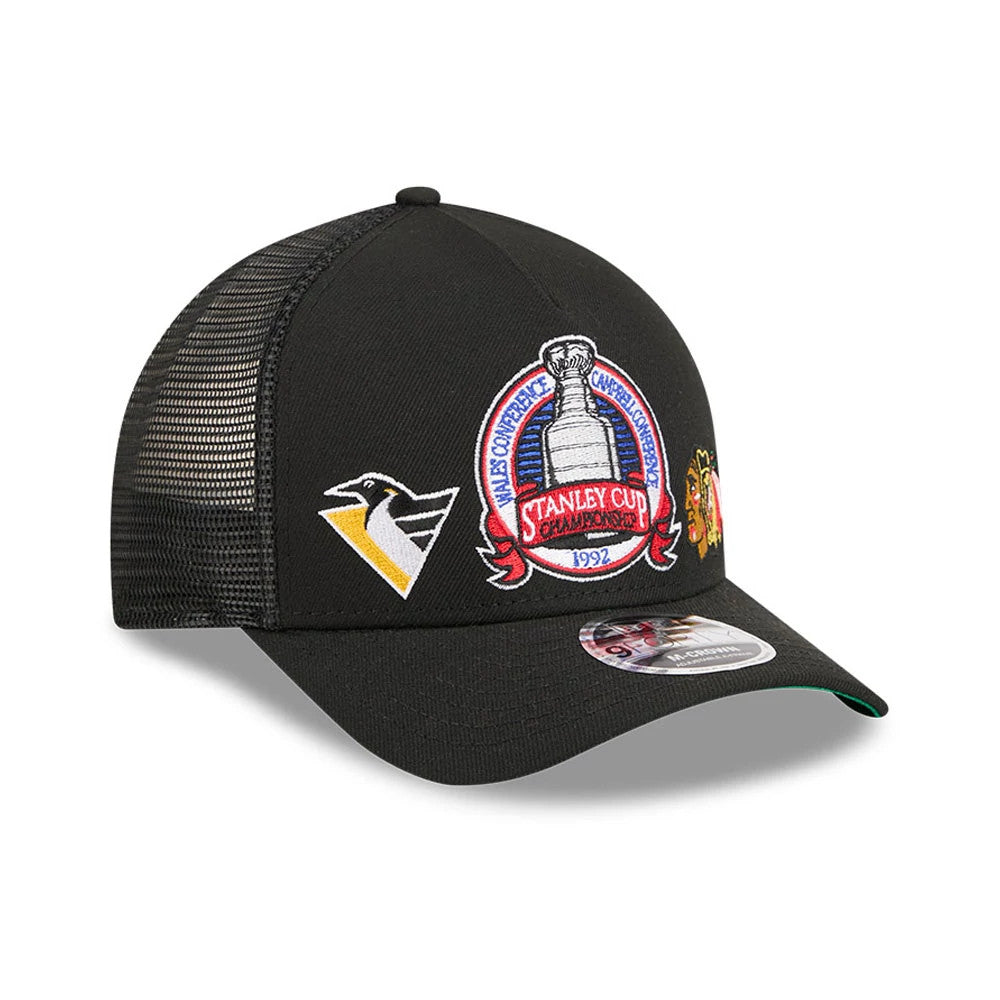 Penguins NHL Stanley Cup Black New Era 9FORTY M-Crown A-Frame Trucker Adjustable Cap, three-quarter view showing the detailed embroidered Stanley Cup logo on the front panel, Penguins side logo in yellow and white.
