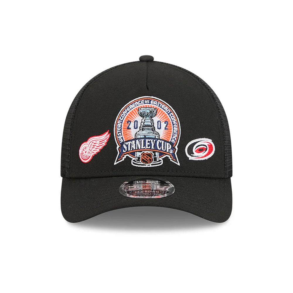 Red Wings NHL Stanley Cup Black New Era 9FORTY M-Crown A-Frame Trucker Adjustable Cap, front view showing the embroidered Stanley Cup patch on the front panel, flanked by the Red Wings and Hurricanes logos.