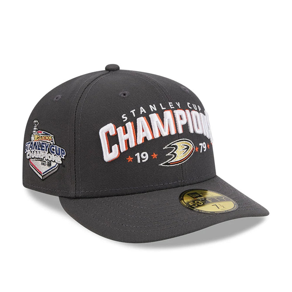 Anaheim Ducks NHL Stanley Cup Champions Dark Grey New Era 59FIFTY Fitted Cap, three-quarter view showing raised white and orange Champions lettering with team logo on the front panel, Stanley Cup patch on the right side.