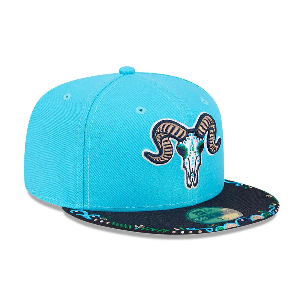 Yard Goats MiLB La Copa 2026 Bright Blue New Era 59FIFTY Fitted Cap, three-quarter view showing a raised embroidered ram skull logo on the front panel, a navy visor with multicoloured floral patterns, and a gold 59FIFTY size sticker.